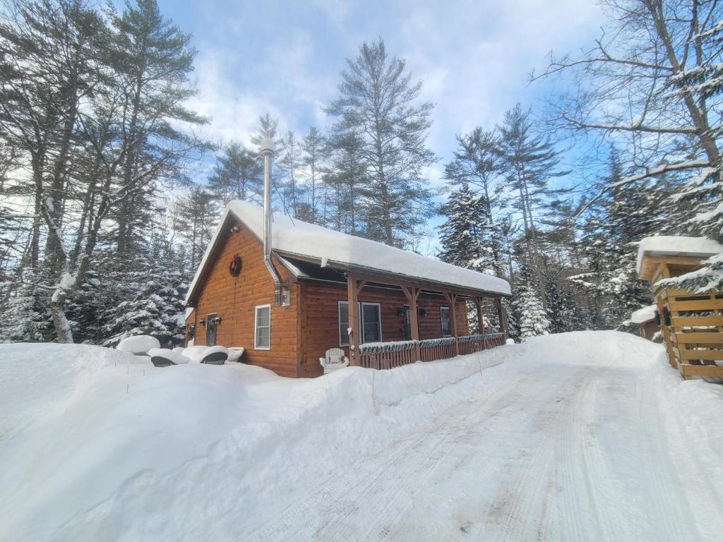 a small wooden cabin with snow on the ground at Ohana cabin in Hanover