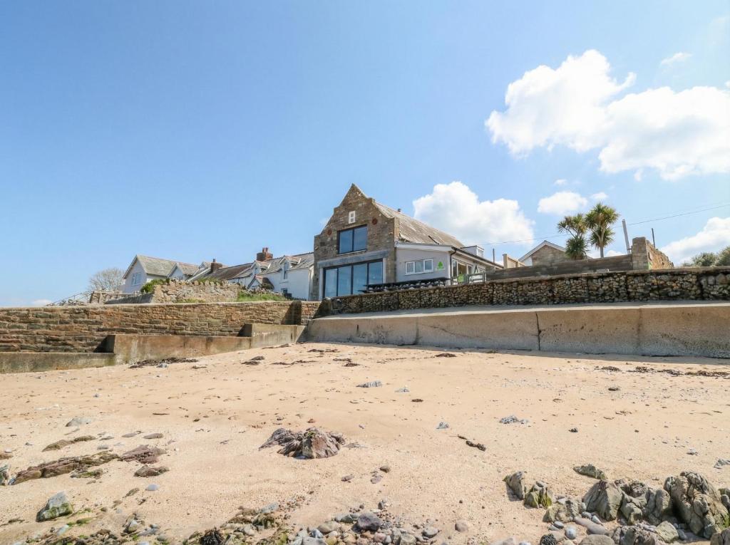 a house on the beach with rocks on the beach at The Boat House - Port Eynon in Swansea