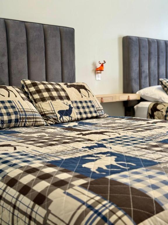 a bed with a checkered blanket and pillows at The Moosehead in Glenwood