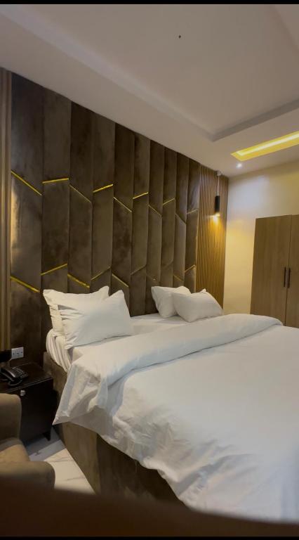 a bedroom with a large bed with white sheets and pillows at Moor Times Hotel in Benin City