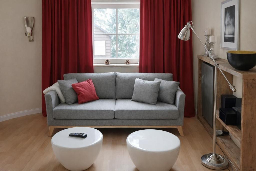 a living room with a couch and red curtains at Chalet Jägerstieg in Braunlage