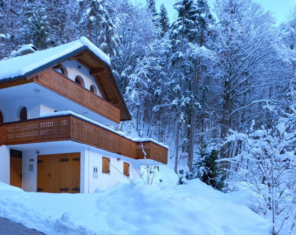 a house covered in snow with trees in the background at Mountain View House - Panoramic! in Gozd Martuljek