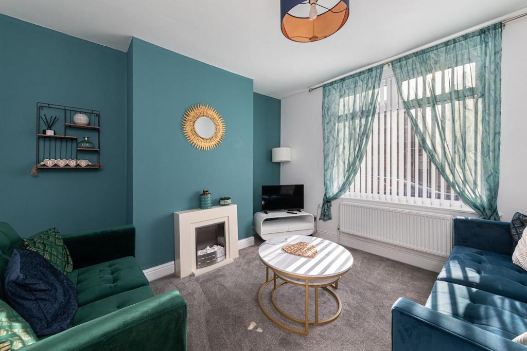 a blue living room with a couch and a table at The Relaxation Station in Bishop Auckland