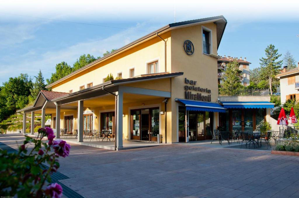 a large building with tables and chairs in front of it at Hotel Dei in Cascia