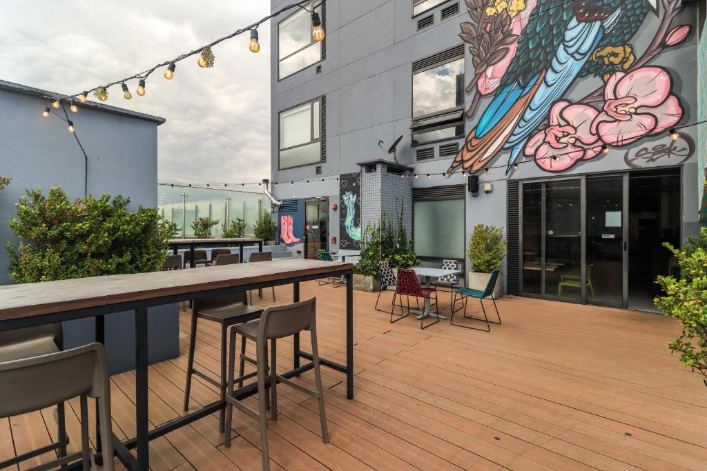 a deck with chairs and tables on a building at Happa Hub Hotel in Bogotá
