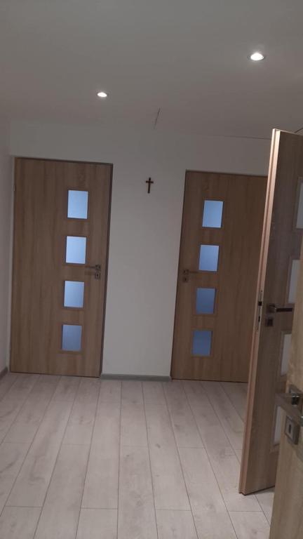 an empty room with two doors and a tile floor at Pokoje do wynajęcia w domku in Ryczówek