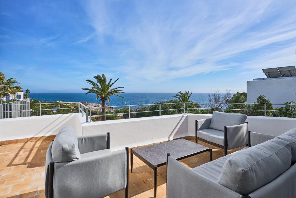 a balcony with chairs and a table and the ocean at Villa Mar Gran in Cacla D'or