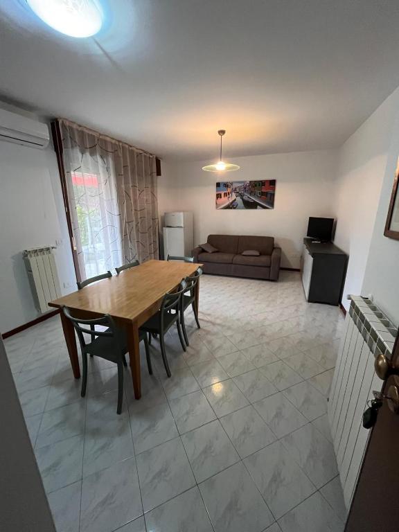 a living room with a table and chairs and a couch at Nuovo Sile in Cavallino-Treporti