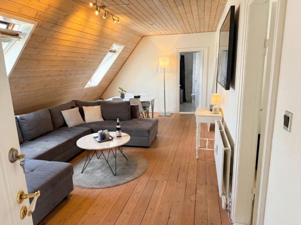 a living room with a couch and a table at Penthouse - 3BR - Esbjerg Island in Esbjerg