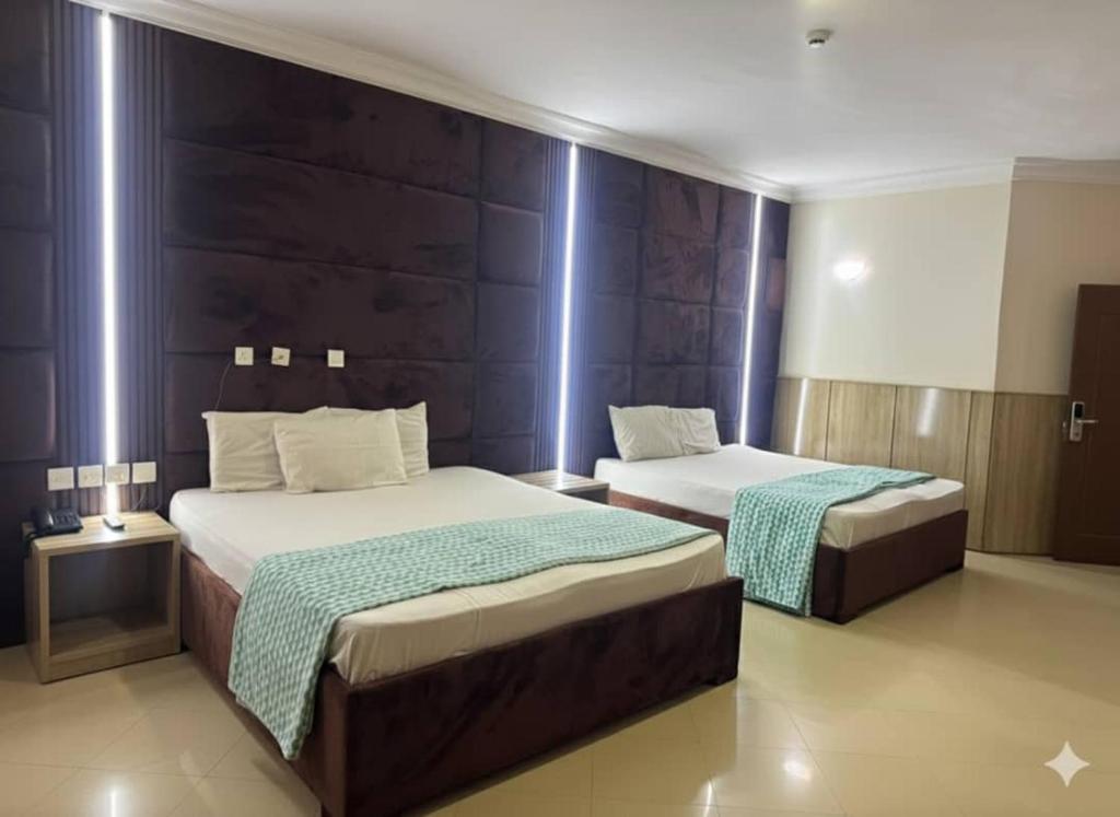 a bedroom with two beds and a wall at DE-George's Grand Resort in Mama
