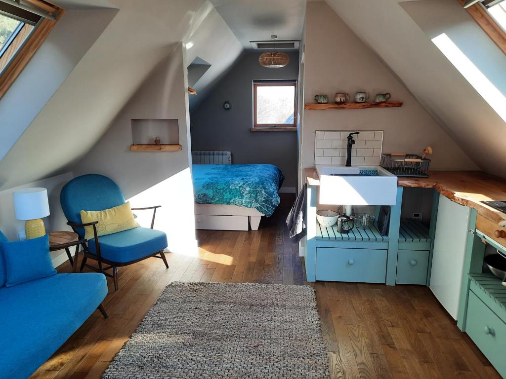 a attic room with a bed and a couch at The Wee Loft in Carrbridge