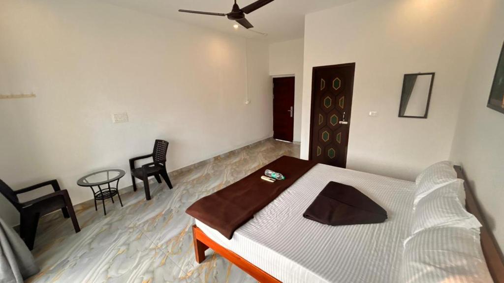 a bedroom with a bed and a table and chairs at La nature in Pondicherry