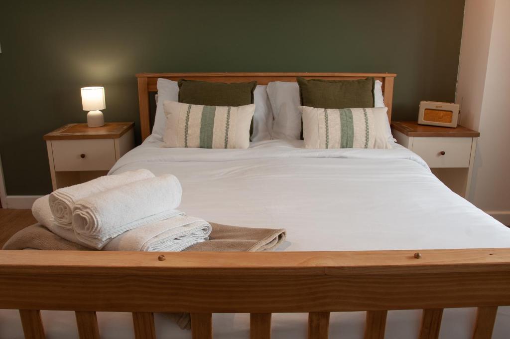 a bedroom with a bed with white sheets and pillows at The Halfway Inn in Morden