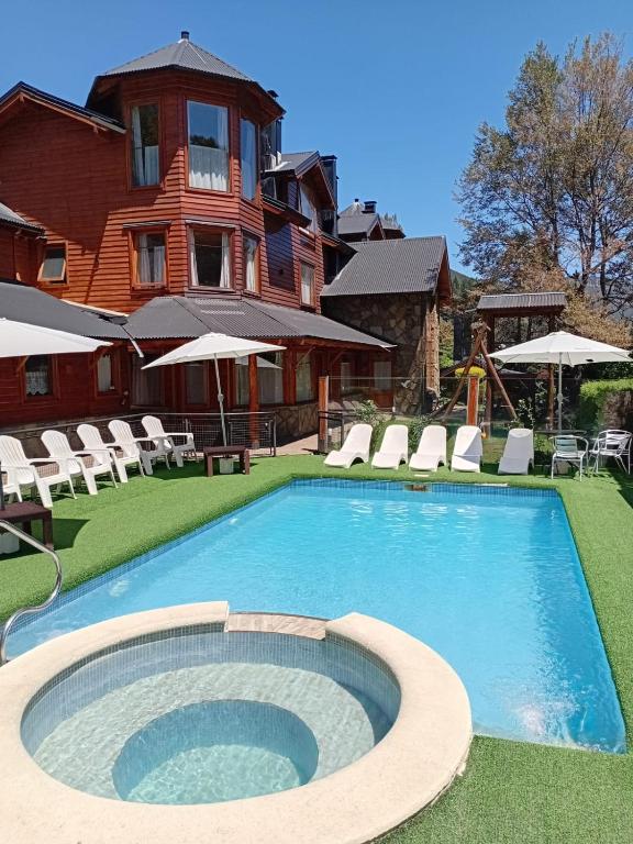 a large swimming pool in front of a house at Apart Hotel del Pellin in San Martín de los Andes