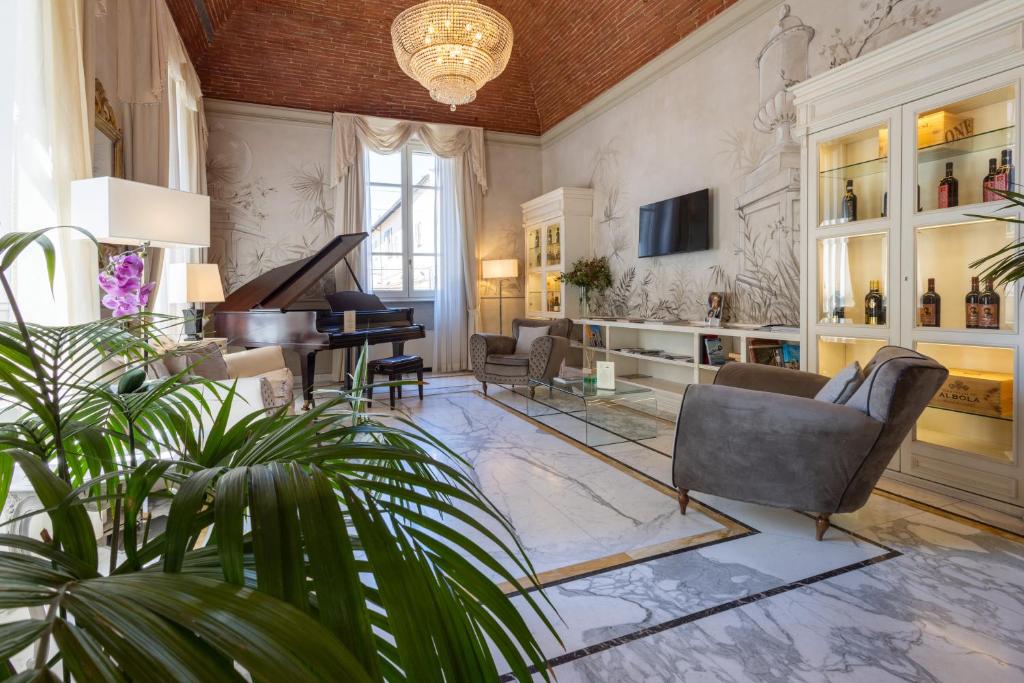 a living room with a piano and a couch and chairs at Hotel Embassy in Florence