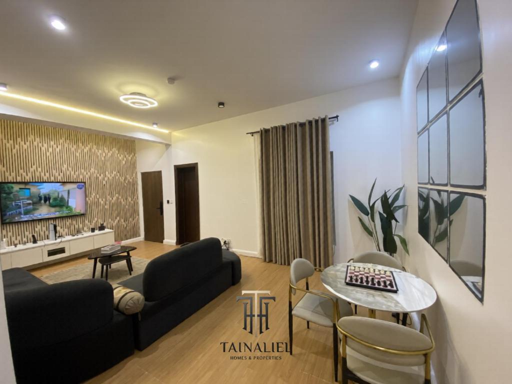 a living room with a couch and a table at Tainaliel Homes and Properties in Mama