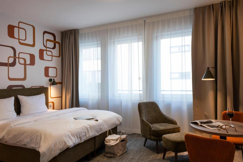 a hotel room with a bed and a chair and a table at HUB Apartments St Georg in Hamburg