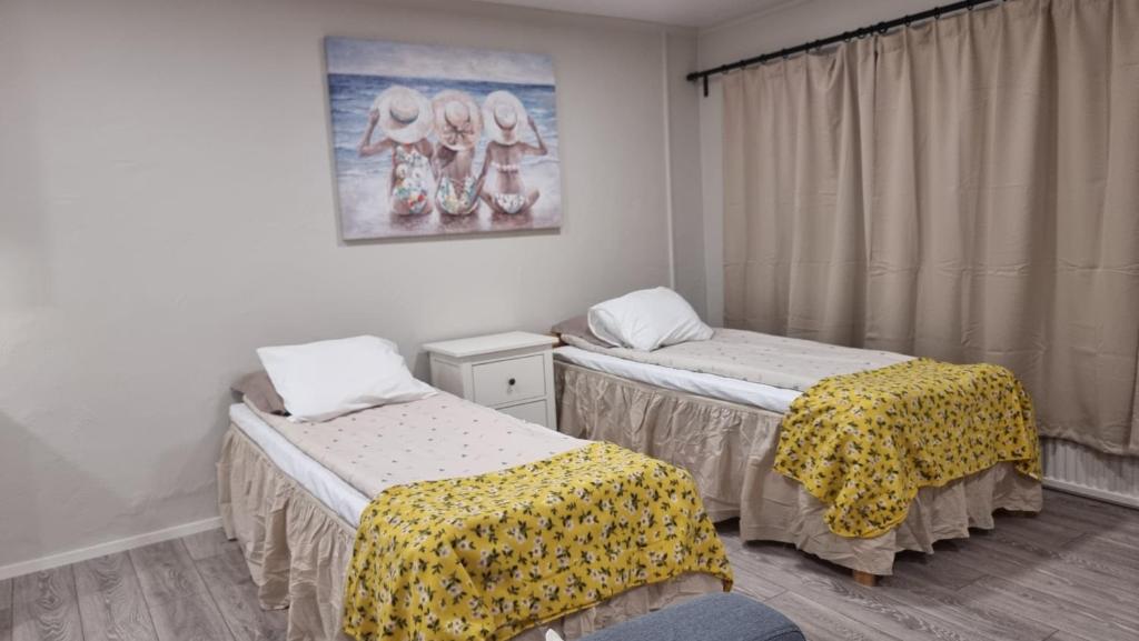 a room with two beds and a picture on the wall at Casa 48 in Lahti