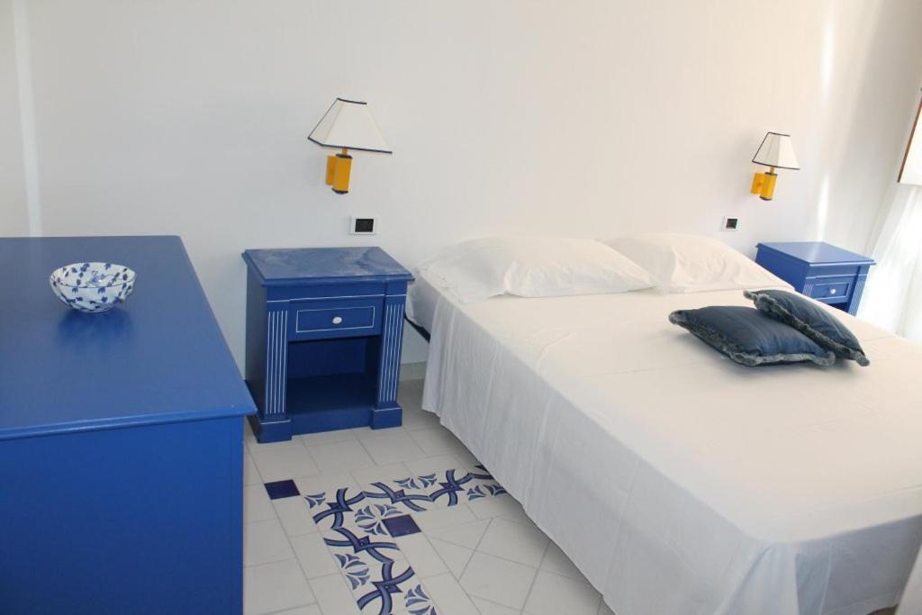 ein blaues Schlafzimmer mit zwei Betten und einem blauen Schreibtisch in der Unterkunft Il quadrifoglio home in Marettimo