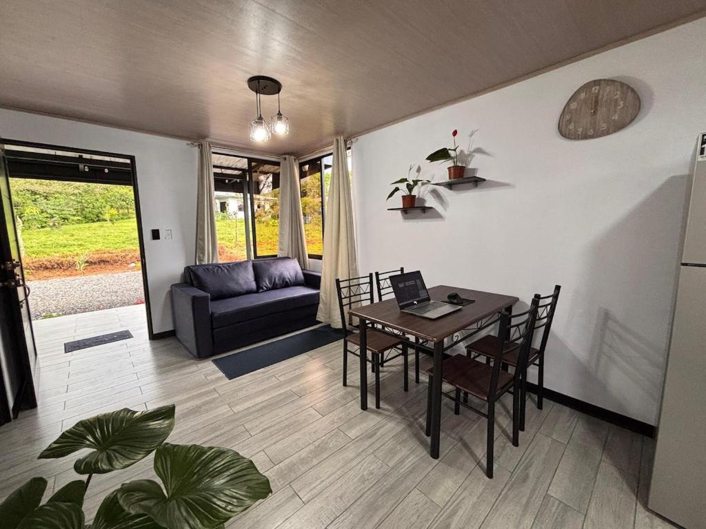 a living room with a table and chairs and a couch at Harmony Home La Fortuna in Fortuna