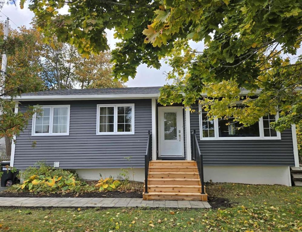 a gray house with a porch and a door at Calm on the Crescent in St. John's