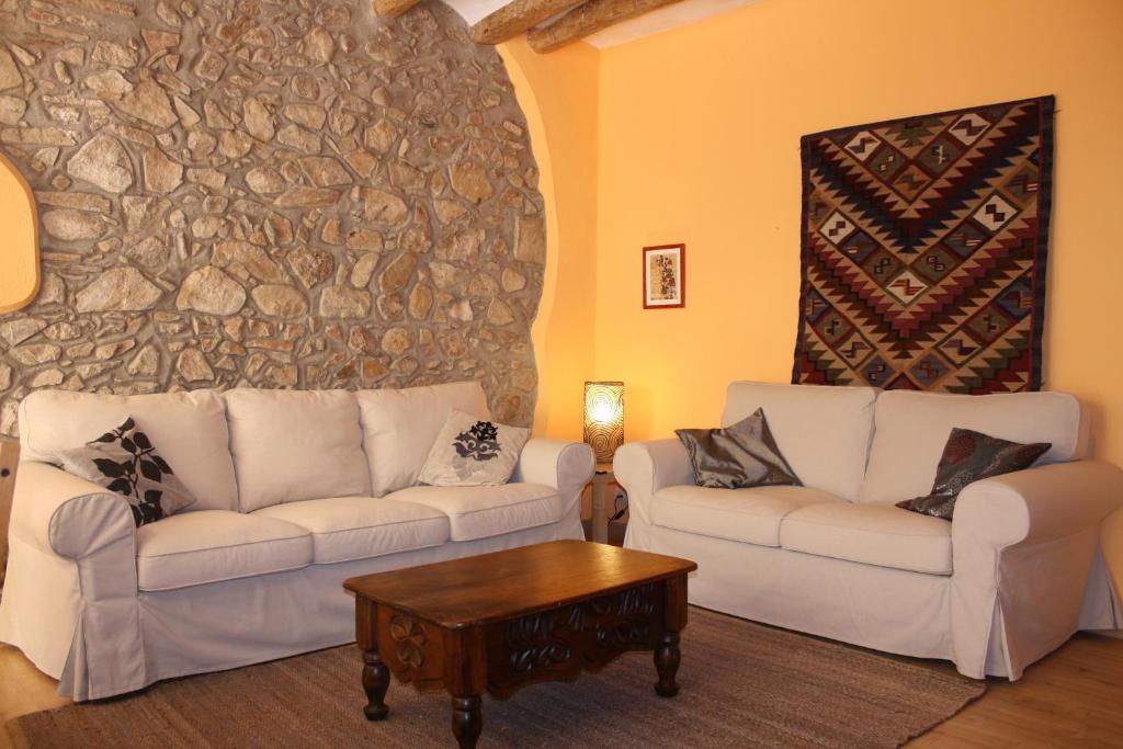 Cal Pedret في Ríudecañas: غرفة معيشة مع كنبتين بيضاء وطاولة