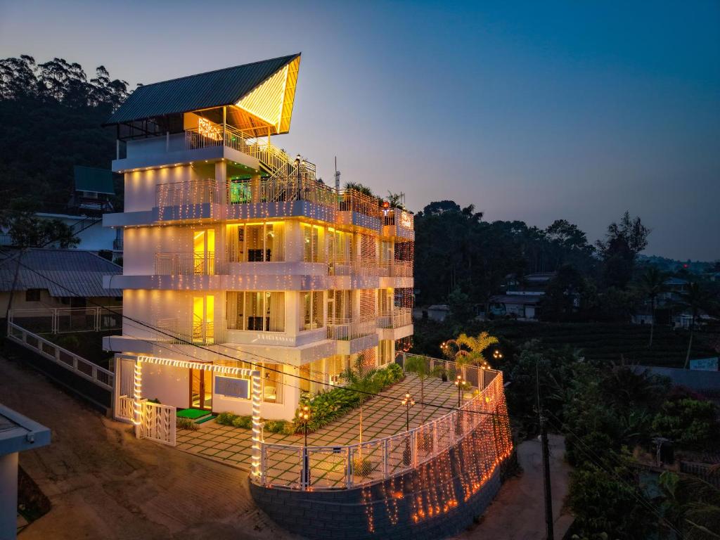 a building with lights on the side of it at Munnar Peak Paradise in Devikolam