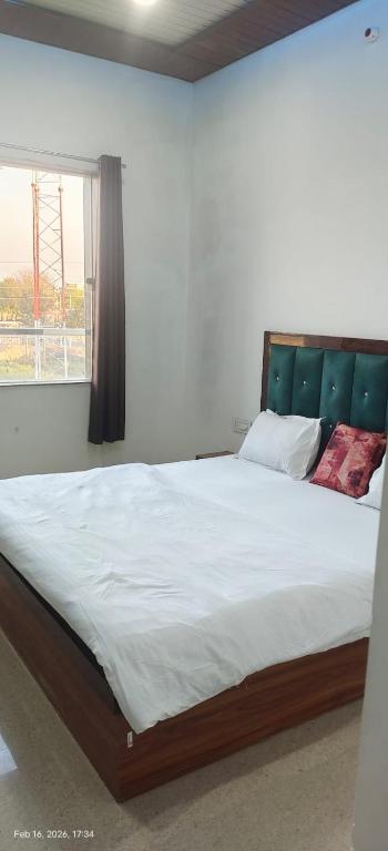 a bedroom with a large bed with a green headboard at Shyam Krapa in Rīngas