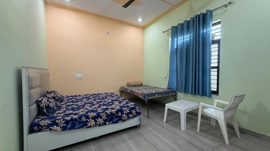 a bedroom with a bed and a table and a chair at The Green Retreat in Murthal