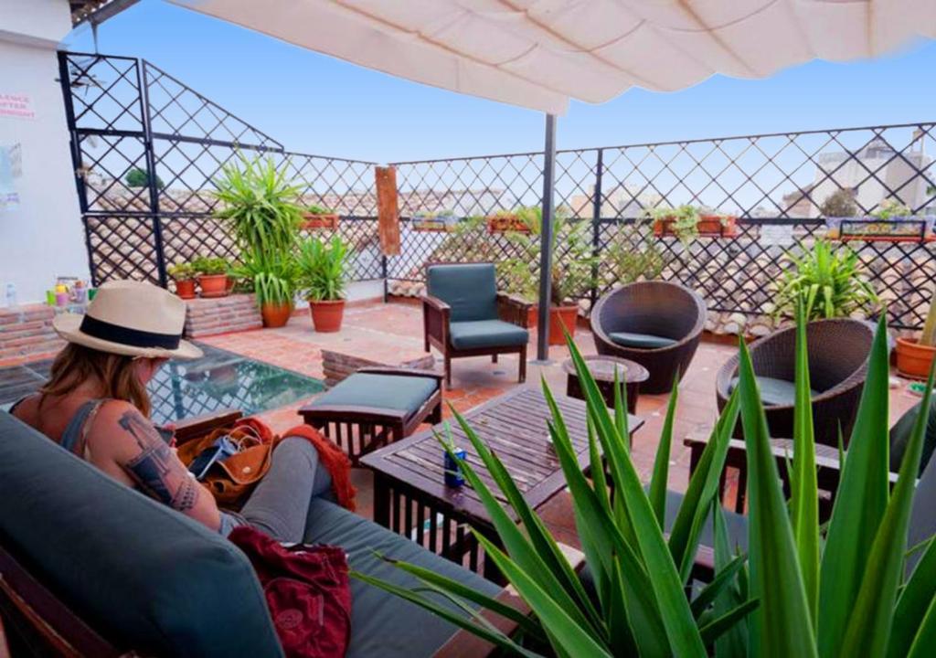 a woman sitting on a couch on a patio at Oasis Backpackers' Hostel Granada in Granada