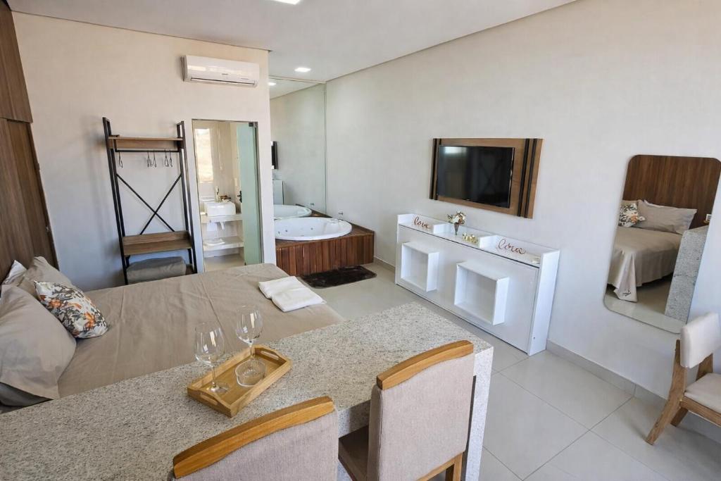 a living room with a dining table and a bathroom at Chalés Brisas do Lago Capitólio in Capitólio
