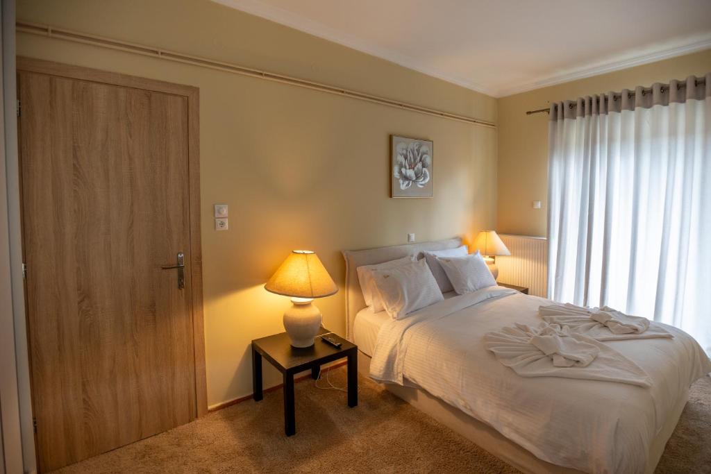 a bedroom with a bed with a lamp and a door at Elitee Superior Mountain Residence in Vitina