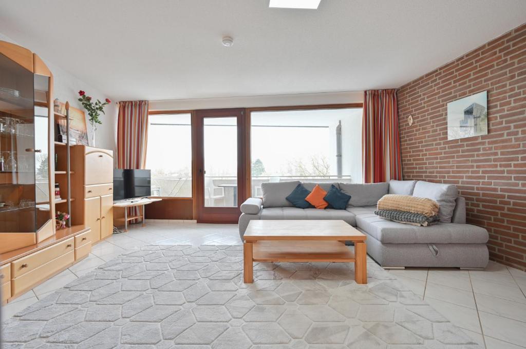 a living room with a couch and a brick wall at FeWo Lange - Whg 48 in Kellenhusen