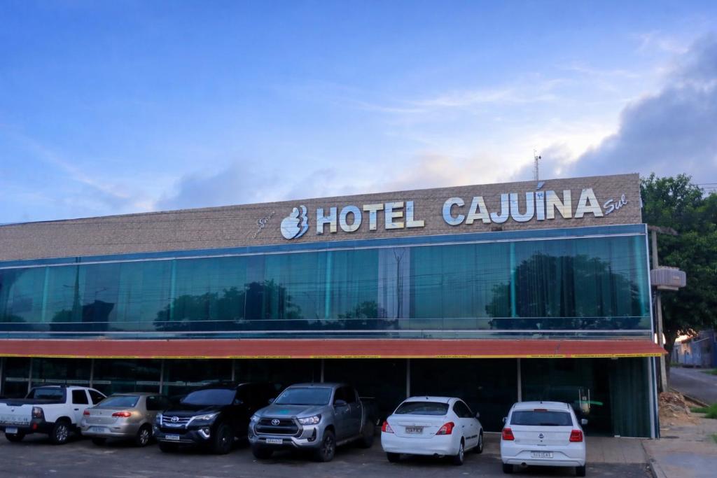 a hotel coluna with cars parked in front of it at Hotel Cajuína Sul in Teresina