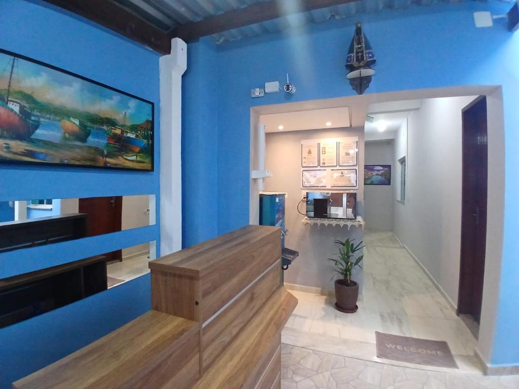 a room with a blue wall with a stair case at Pousada Milagres de Maria in Aparecida