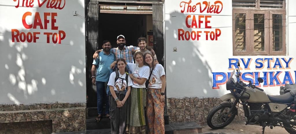 a group of people standing in a doorway with a motorcycle at Rv stay pushkar in Pushkar