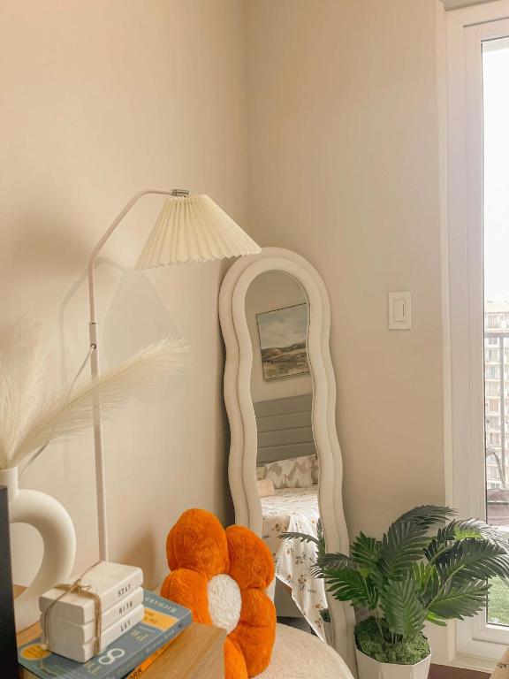 a teddy bear sitting on a bed in front of a mirror at Condo at 16th Floor Free Pool Access with Private Balcony in Suba