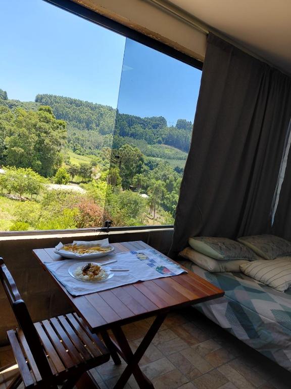a table in a room with a large window at Recanto Colina in Picada Cafe