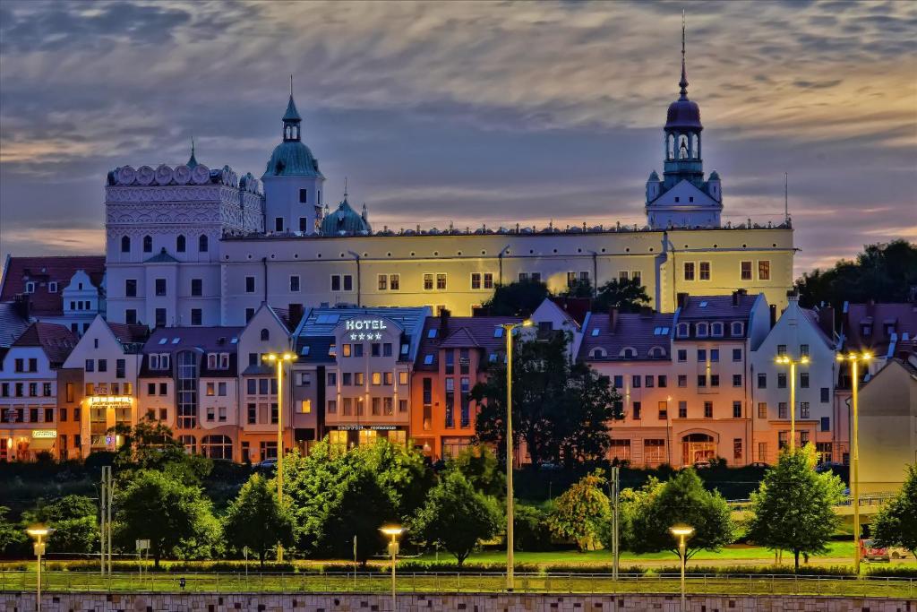 a view of a large building at night at Hotel Zamek Centrum in Szczecin