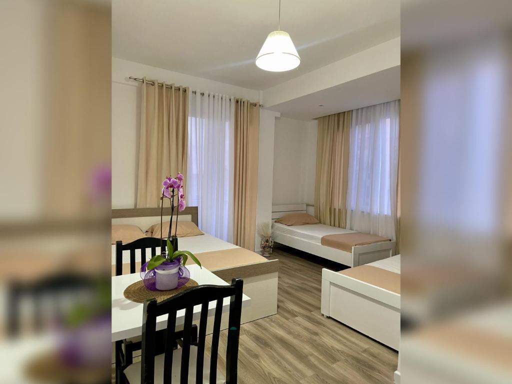 a room with a bed and a table with a dining room at Marra’s Rooms in Durrës
