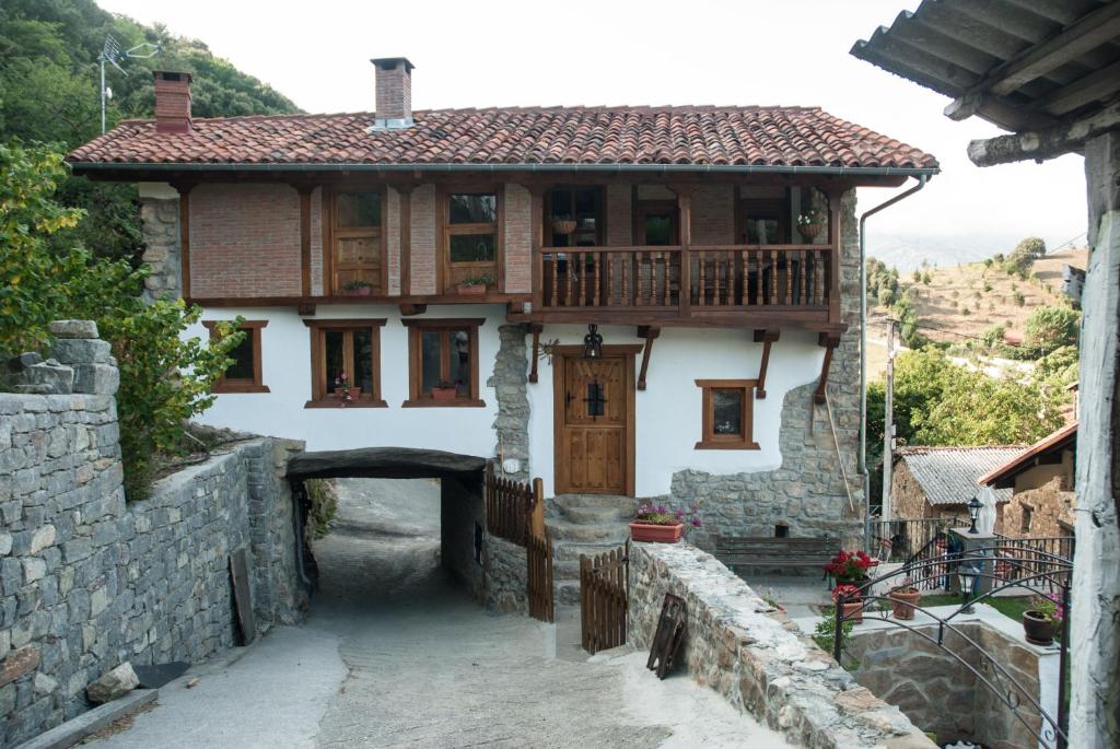 uma casa com uma varanda em cima em El Mijolar Apartamentos em Armaño