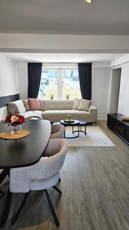 a living room with a table and a couch at Sauerland Apartments in Schwalefeld