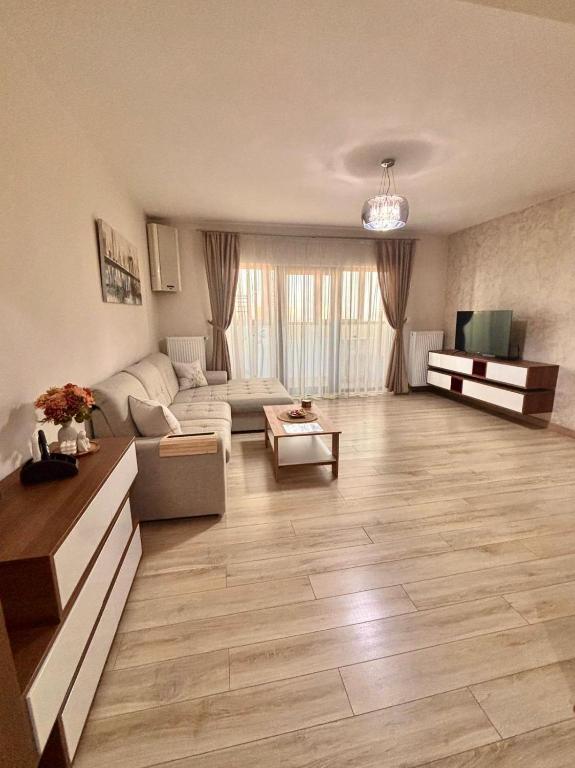 a living room with a couch and a table at Sweet Home Apartment in Piteşti