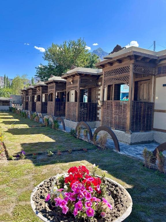 a garden with flowers in front of a building at Zimsa Resort Skardu in Skardu
