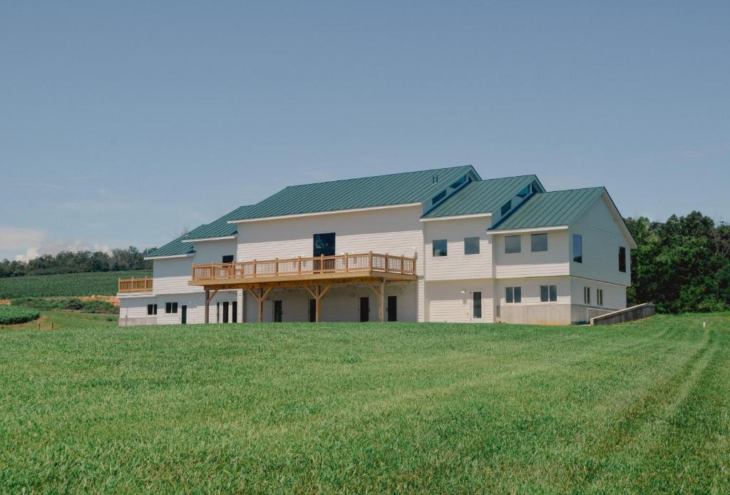 a large house with a green roof on a field at New Field Farm at Timber Ridge in Lexington