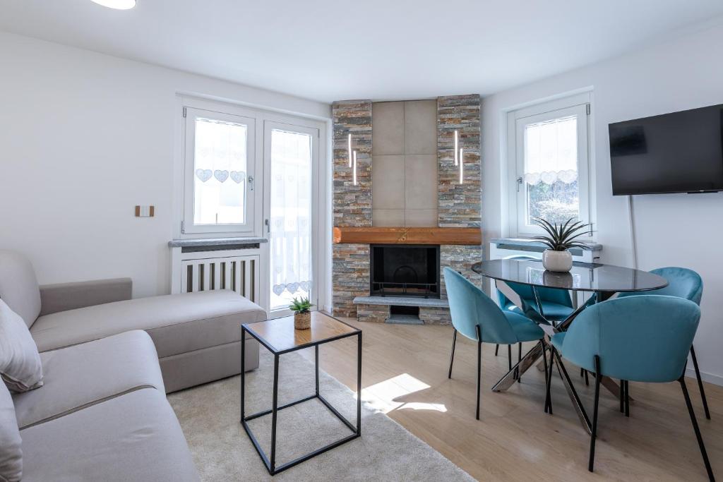 a living room with a couch and a table and chairs at Blanc 4810 in Pré-Saint-Didier