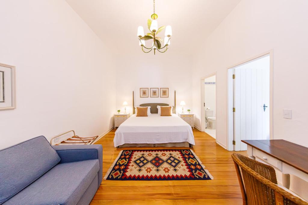 a living room with a bed and a couch at Fazenda Santanna Hotel in Amparo