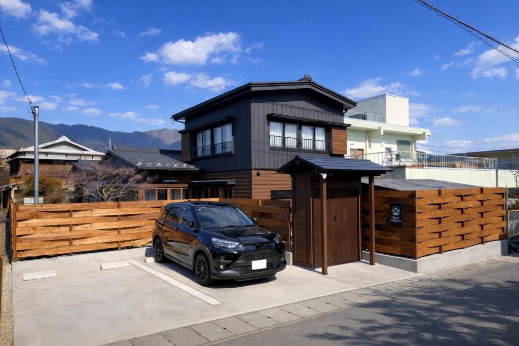 a car parked in a parking lot in front of a house at Three Maples Fujiyoshida in Fujiyoshida