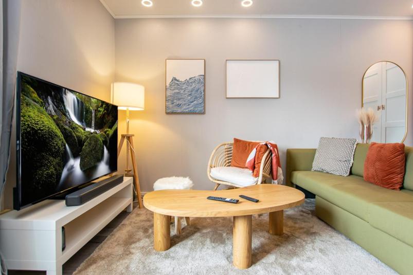 a living room with a couch and a tv at Coastal Wooden Apartment Rauma in Rauma