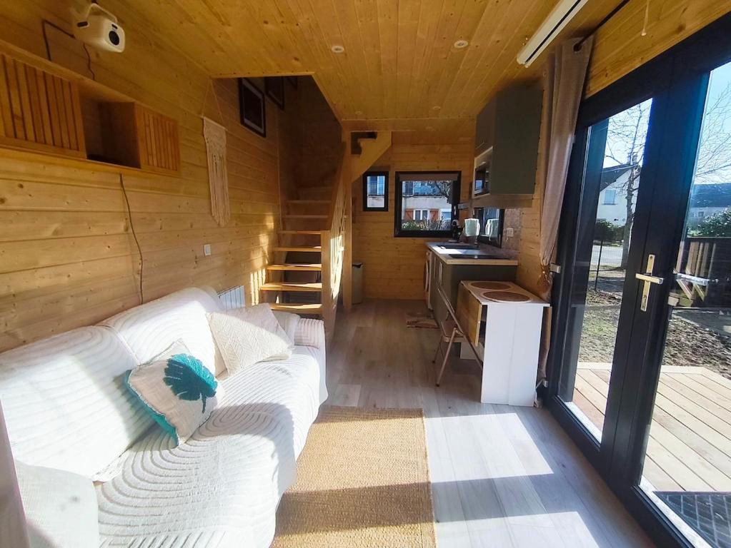 a living room with a white couch in a tiny house at chalet bohème au calme in Saint-Ambreuil